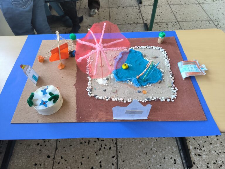 Foto eines gebastelten Modells eines Sandkasten mit Wasserbeckens und Sonnenschirm